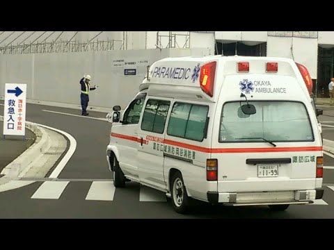 工事現場の誘導員が救急車を誘導する