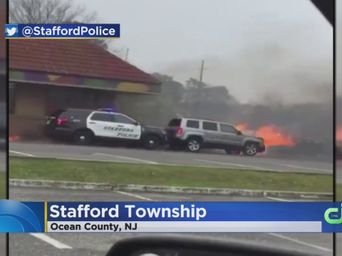 レストラン前で炎上する車を押し出すパトカー