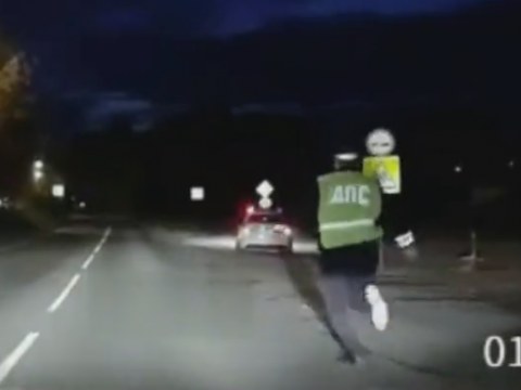 クリープ現象で勝手に走っていくパトカーを追いかける警官