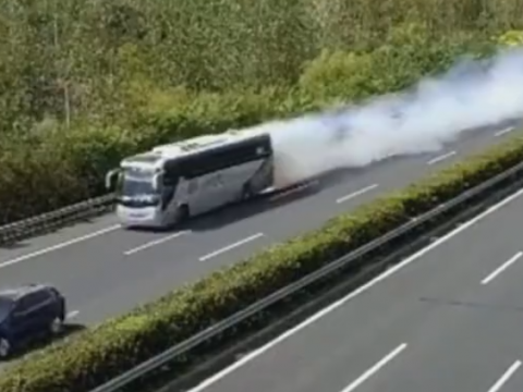 中国の高速道路で発煙しながら走るバス