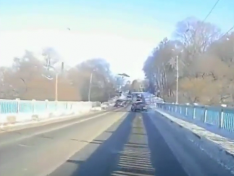 橋の上でスリップする乗用車