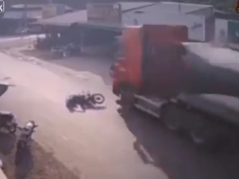 こけたバイクに迫るトラック