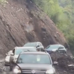 崖が崩れてくる中を通過する車たち