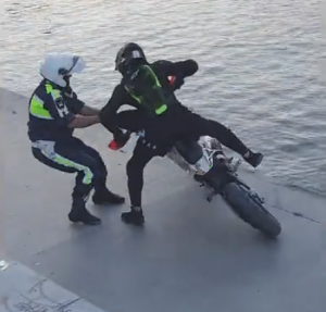バイクから犯人を引きずり下ろす警官