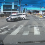 交差点内で転回するパトカーが白い車と接触する様子